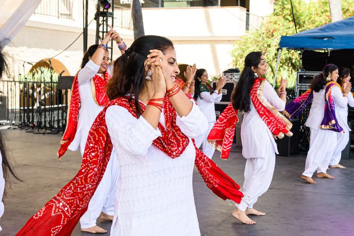 Close-up of dancers performing Bhangra in red and white