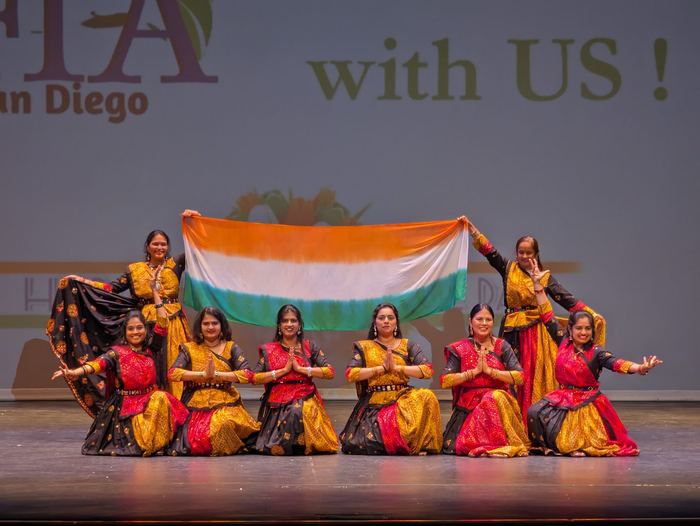 Dancers on stage holding the Indian flag