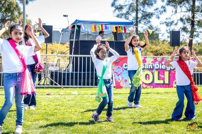 Kids performing outdoors at a Holi event