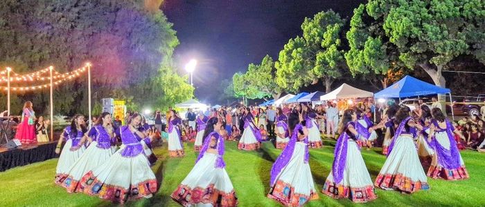 Group dancing outdoors at night under string lights